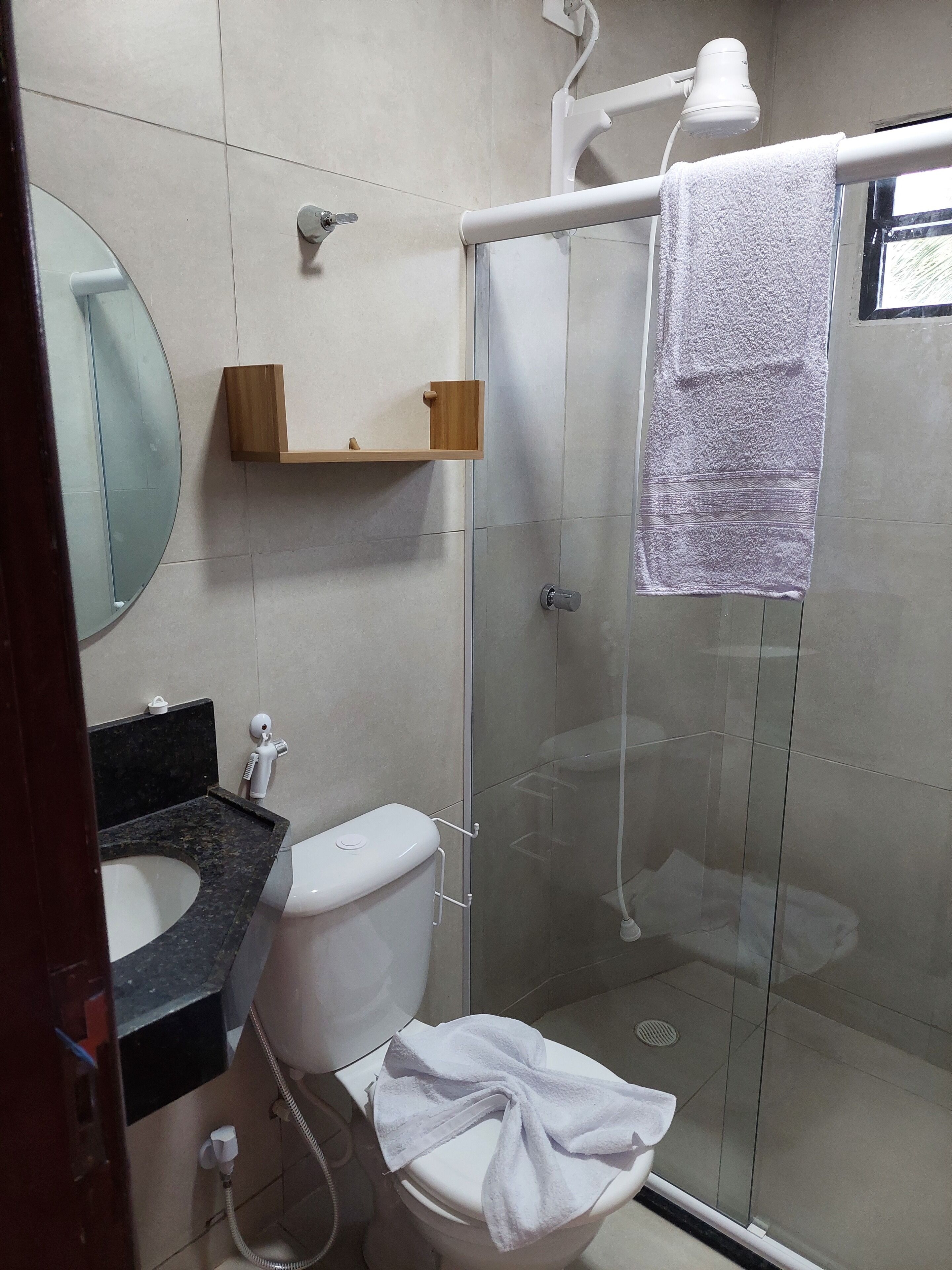A modern bathroom with a toilet, sink, and shower.