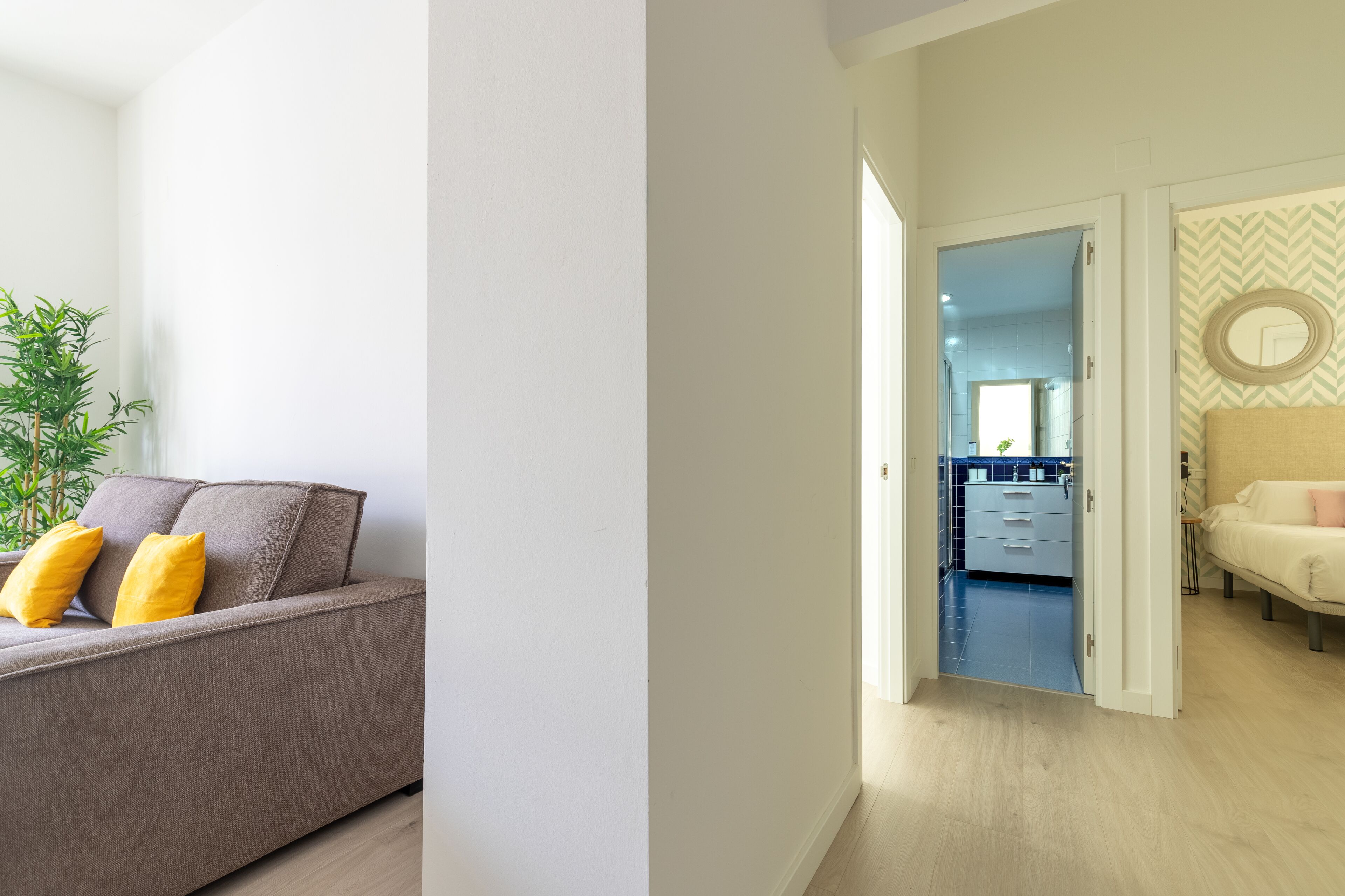 Una sala de estar moderna con un sofá y una planta en maceta.
