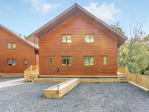 A wooden cabin with a sloped roof, multiple windows, and a wooden deck. - Waterside Lodge Six - UK38264 (Elland)