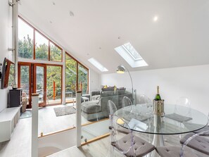 A modern living room with a glass table, clear chairs, a sofa, and a fireplace. - Waterside Lodge Six - UK38264 (Elland)