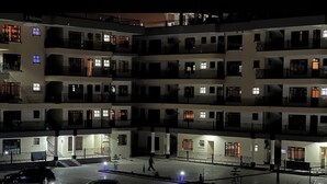 Un hôtel à plusieurs étages, doté de balcons et de fenêtres illuminées la nuit.