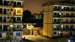 Un hôtel à plusieurs étages doté de balcons, d’une cour intérieure et d’une entrée bien éclairée.