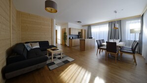 A modern apartment with a living room, dining area, and kitchen.
