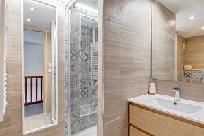A modern bathroom with a shower, a sink, and a mirror. - Le Gentiana - Triplex vue montagne (Saint-Nicolas-la-Chapelle)