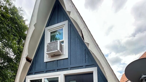 A small, dark blue building with a triangular roof, a window, and a door. - Table Rock Lake Cabin @ Black Oak Resort (Lampe)
