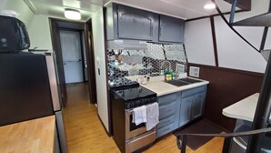 A compact kitchen with a stove, oven, microwave, and a small countertop. - Table Rock Lake Cabin @ Black Oak Resort (Lampe)