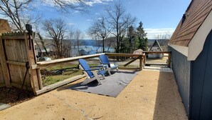 A covered patio area with blue chairs and a wooden deck. - Table Rock Lake Cabin @ Black Oak Resort (Lampe)