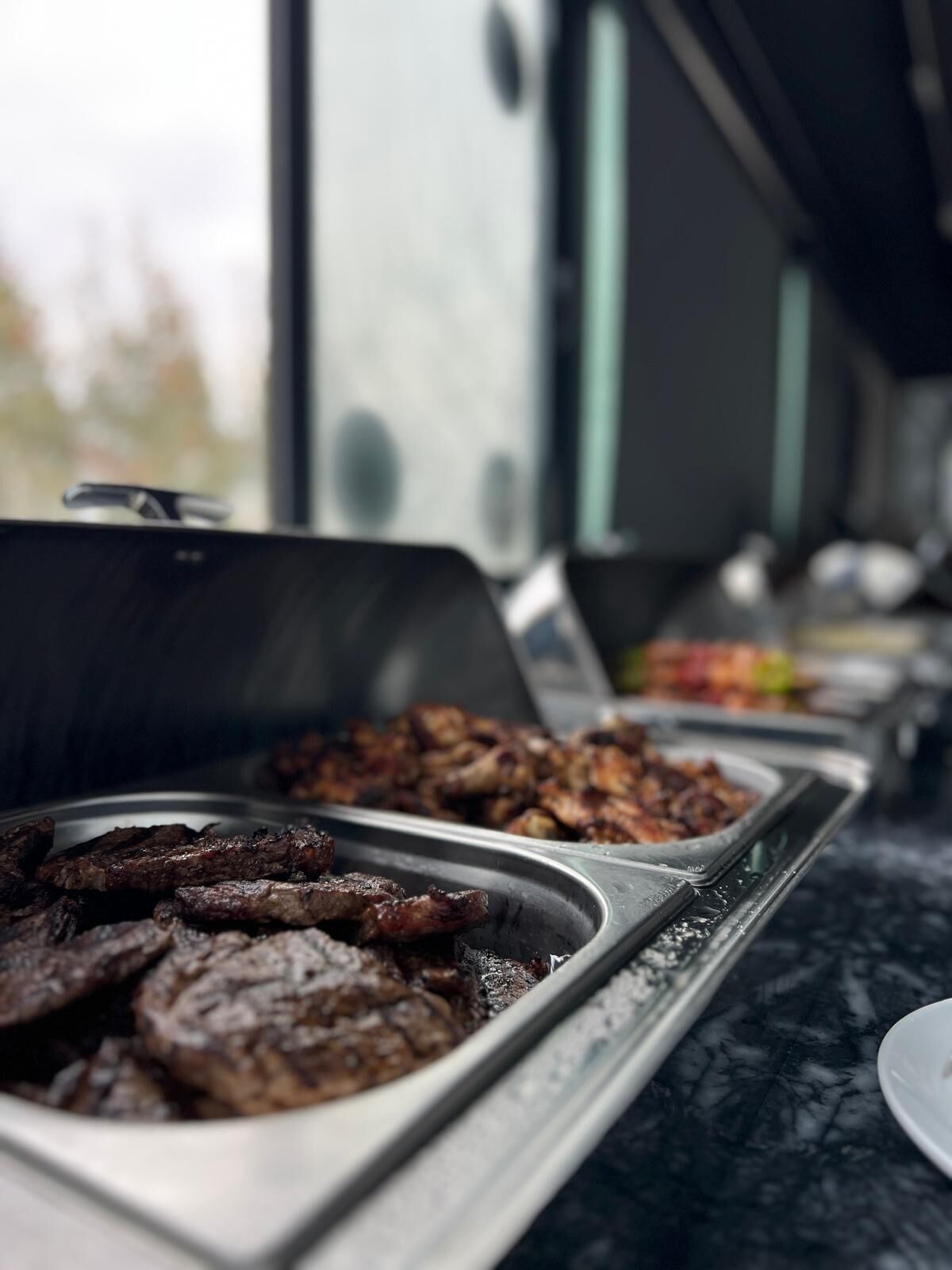 A buffet with various food items, including grilled meats and other dishes.