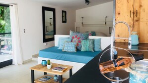 Una sala de estar moderna con un sofá, una mesita de centro y una cocina con un lavamanos y grifo.