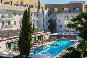 Relax by the rooftop pool with lounge chairs and umbrellas.