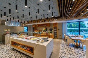 Enjoy a meal at the central buffet area, featuring a variety of food and beverages.