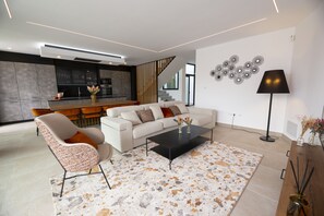 A modern living room with a sofa, coffee table, and a patterned rug.