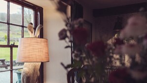 Eine Lampe mit einer strukturierten Schirm auf einem Holztisch in der Nähe eines Fensters.