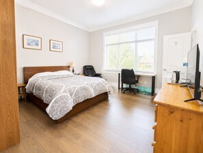 A bedroom with a bed, a desk, a chair, a TV, and a window. - Cozy, Bright, Private Room (Coquitlam)