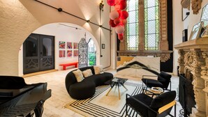 A spacious lobby with a black sofa, a chess table, and a fireplace. - UTOPIC Campos Elíseos by ULIV (Mexico City)