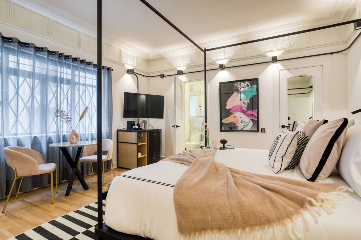 Una camera da letto con un letto grande, una TV, una scrivania e una sedia.