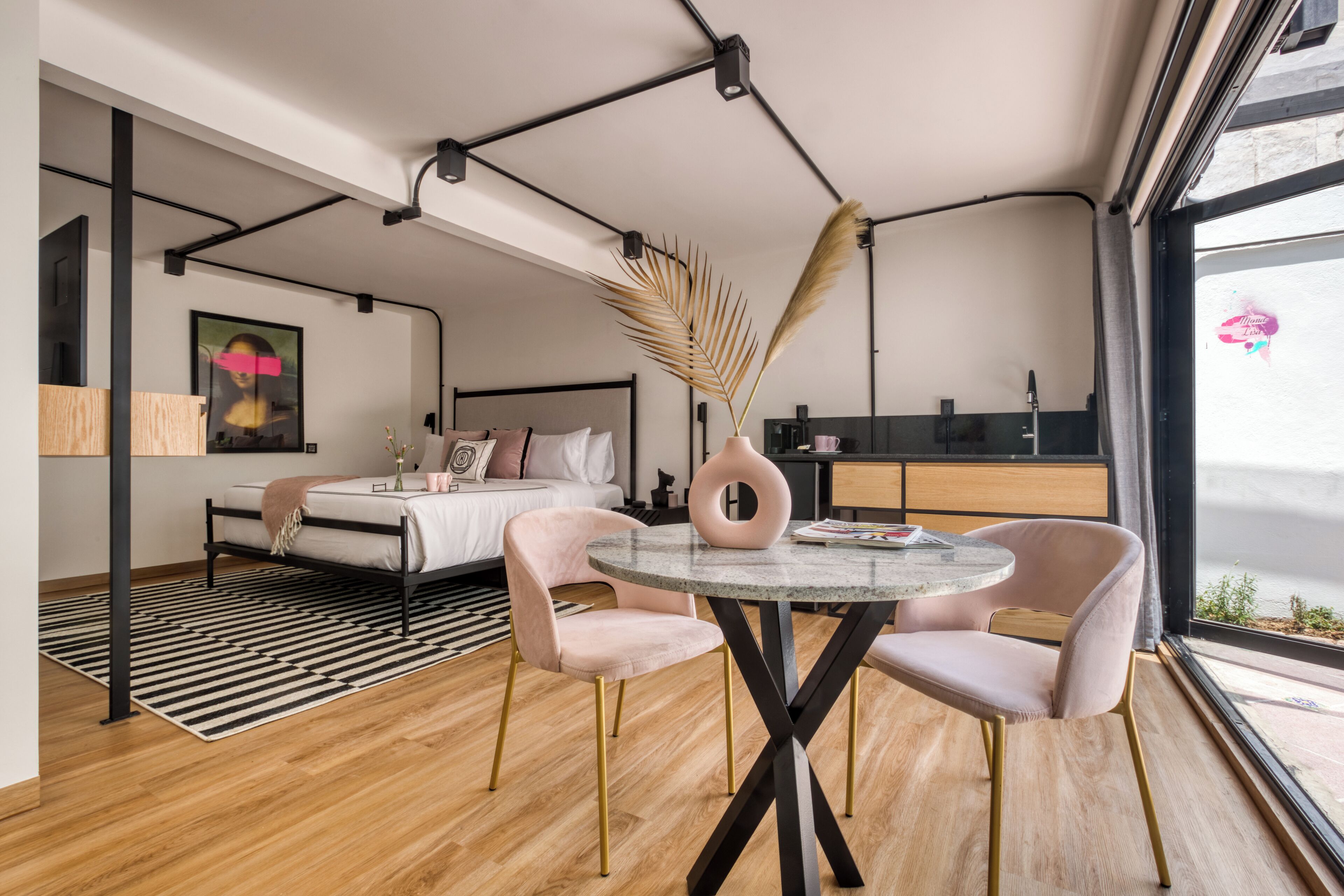 Un dormitorio moderno con cama, mesita de noche y un amplio ventanal.