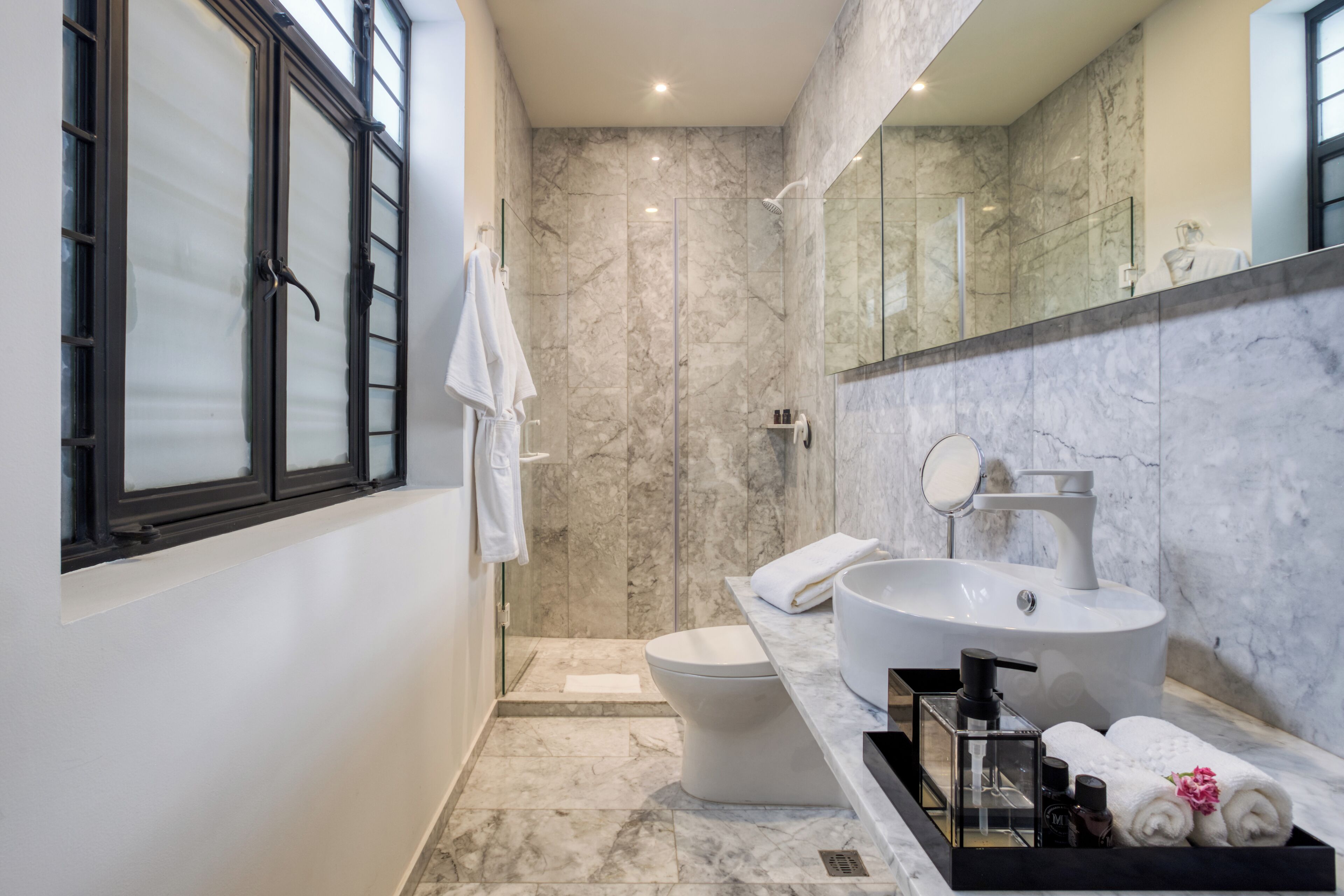 Ein modernes Badezimmer mit einem großen Waschbecken, Toilette und Duschbereich.