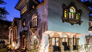 A historic building with arched windows and ornate detailing, featuring a well-lit entrance and a garden area. - UTOPIC Campos Elíseos by ULIV (Mexico City)
