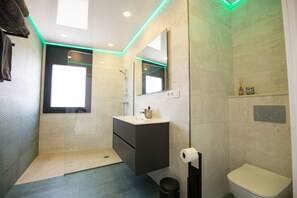 A modern bathroom with a shower, toilet, and vanity. - A magnificent contemporary villa right in the city center, a 3-minute walk from the beach and restaurants. (Empuriabrava)
