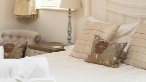 A bedroom with a bed, a nightstand, a lamp, a chair, and a window with blinds. - 2 bedroom accommodation in Wrelton, near Pickering (Wrelton, near Pickering)