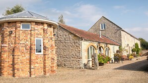 A traditional stone building with a circular water tower, a stone house with a pitched roof, and a gravel driveway. - 2 bedroom accommodation in Wrelton, near Pickering (Wrelton, near Pickering)
