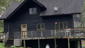 Eine Holzhütte mit einem Balkon, einer Satellitenschüssel und einer kleinen Veranda.