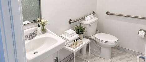 A modern bathroom with a white sink, toilet, and bathtub.