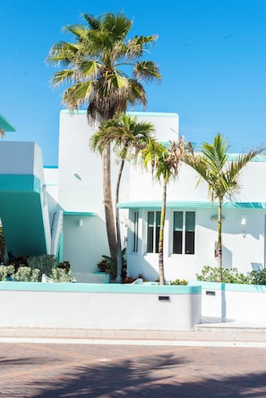 A modern building with a white facade and teal accents, surrounded by palm trees. - The Marlin Beachside (Hollywood)