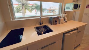 A kitchen with a window, a microwave, a toaster, and a kettle. - The Marlin Beachside (Hollywood)