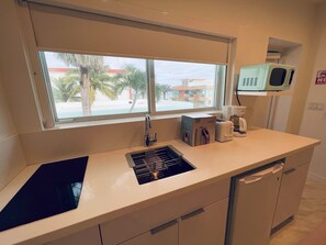 A kitchen with a window, a microwave, a toaster, and a kettle. - The Marlin Beachside (Hollywood)