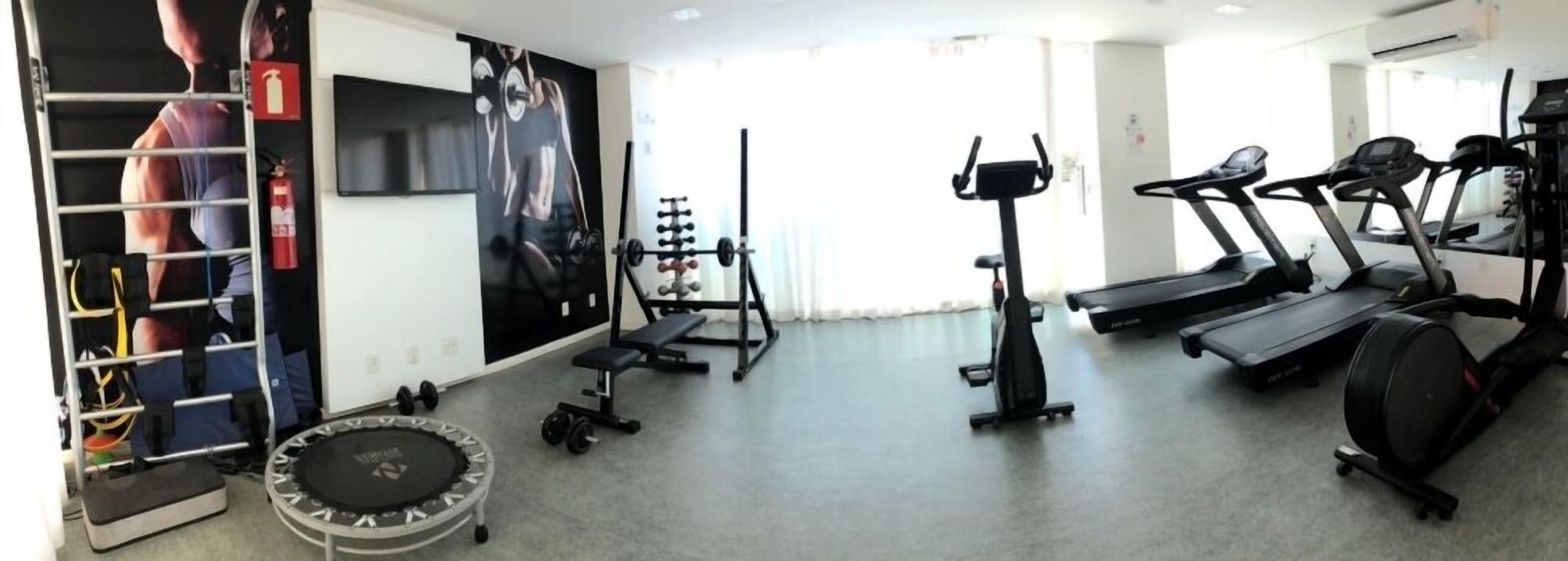 A gym with treadmills, a weight bench, and a squat rack.