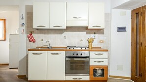 Une cuisine moderne avec des armoires blanches, un plan de travail en bois et un four encastré.