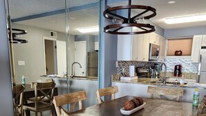 Una cocina moderna con una isla grande, sillas de madera y una mesa de comedor.