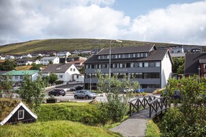 Ein modernes Hotel mit flachem Dach, mehreren Etagen und einer gut sichtbaren Beschilderung.