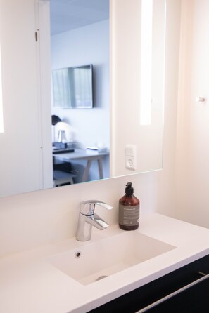 Een douche, handdoeken, zeep, shampoo