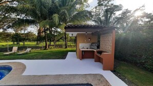 Um quintal com área de churrasco, ofurô e piscina.