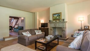 A living room with a fireplace, two sofas, a coffee table, and a television. - Casale dei Tigli 8, Emma Villas (Castel Giorgio)