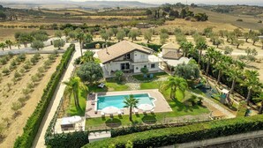 A large house with a swimming pool, surrounded by palm trees and a well-maintained lawn. - Villa Alessia 6, Emma Villas (Gela)