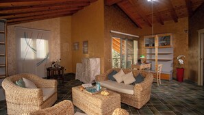 A cozy living room with wicker furniture, a white sofa, and a coffee table with snacks. - Villa Alessia 6, Emma Villas (Gela)