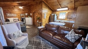 Interior acogedor de una cabaña con sala de estar, comedor y cocina.