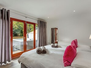 Quarto de hotel com cama, janela grande e vista para o exterior.