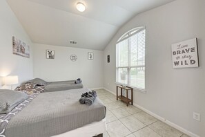 A bedroom with two beds, a window with blinds, a bedside table with a lamp, and wall decorations including a motivational quote. - 2 Story 4 Bedroom Modern Home near Kalahari Resort (Round Rock)