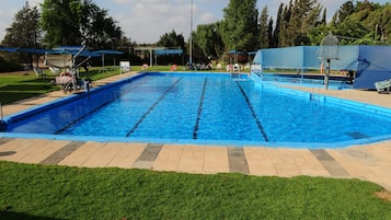 Een seizoensgebonden buitenzwembad, parasols voor strand/zwembad