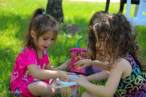 Deux enfants jouent avec des jouets sur l’herbe.