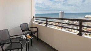 A balcony with two chairs and a small table, overlooking a cityscape and the ocean. - Two Bedroom Deluxe, Luxury Condo, Atlantic City, NJ  2730150 (Atlantic City)