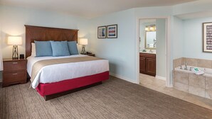 A hotel room with a large bed, bedside tables with lamps, a bathroom with a sink and mirror, and light blue walls. - Two Bedroom Deluxe, Luxury Condo, Atlantic City, NJ  2730150 (Atlantic City)