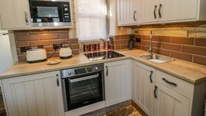 Una cocina compacta equipada con microondas, tostadora, hervidor y horno.