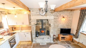 Un salón acogedor con chimenea de piedra, televisor y un espacio de estar confortable.