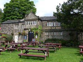Un edificio de piedra tradicional con un letrero que dice 'Haworth Old Hall'.